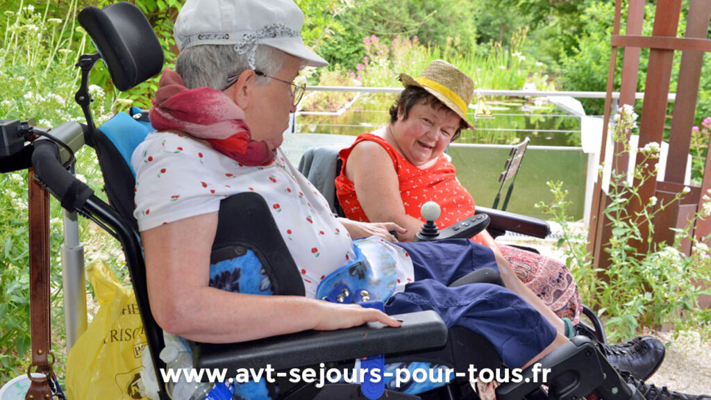 Deux femmes en fauteuil roulant se promènent en pleine nature. Séjour de vacances adaptées organisé par l'association AVT séjours pour tous.