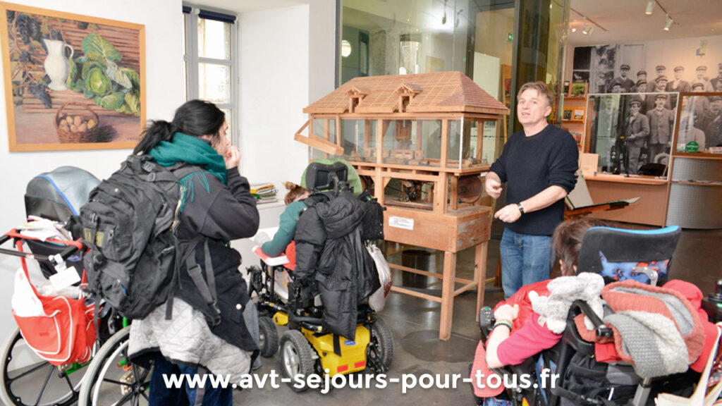 Un groupe de vacanciers en fauteuil roulant visite le musée du Trièves. Activité culturelle proposée lors d'un séjour de vacances adaptées organisé par l'association AVT séjours pour tous dans la région Rhône-Alpes