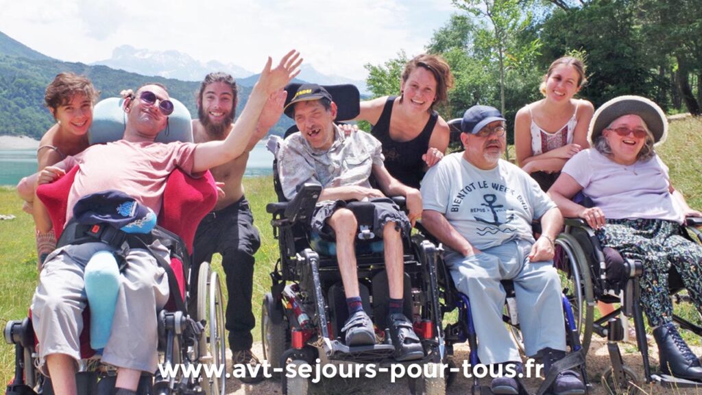 Un groupe de vacanciers adultes handicapés en fauteuil roulant et leurs accompagnateurs lors d'un séjour de vacances adaptées. Promenade en pleine nature près d'un lac. Gîte de groupe géré par AVT Séjours pour tous en Isère, dans le Vercors Trièves.